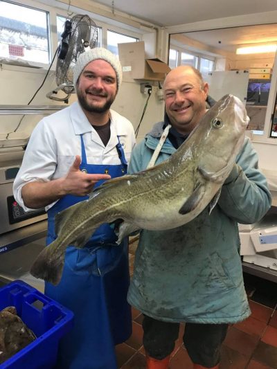 Fisherman and Fishmonger in East wittering holding a huge Local South Coast Cod
